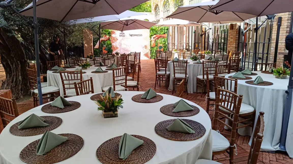 Sousplats de rattan e cadeiras Tiffany sob ombrelones