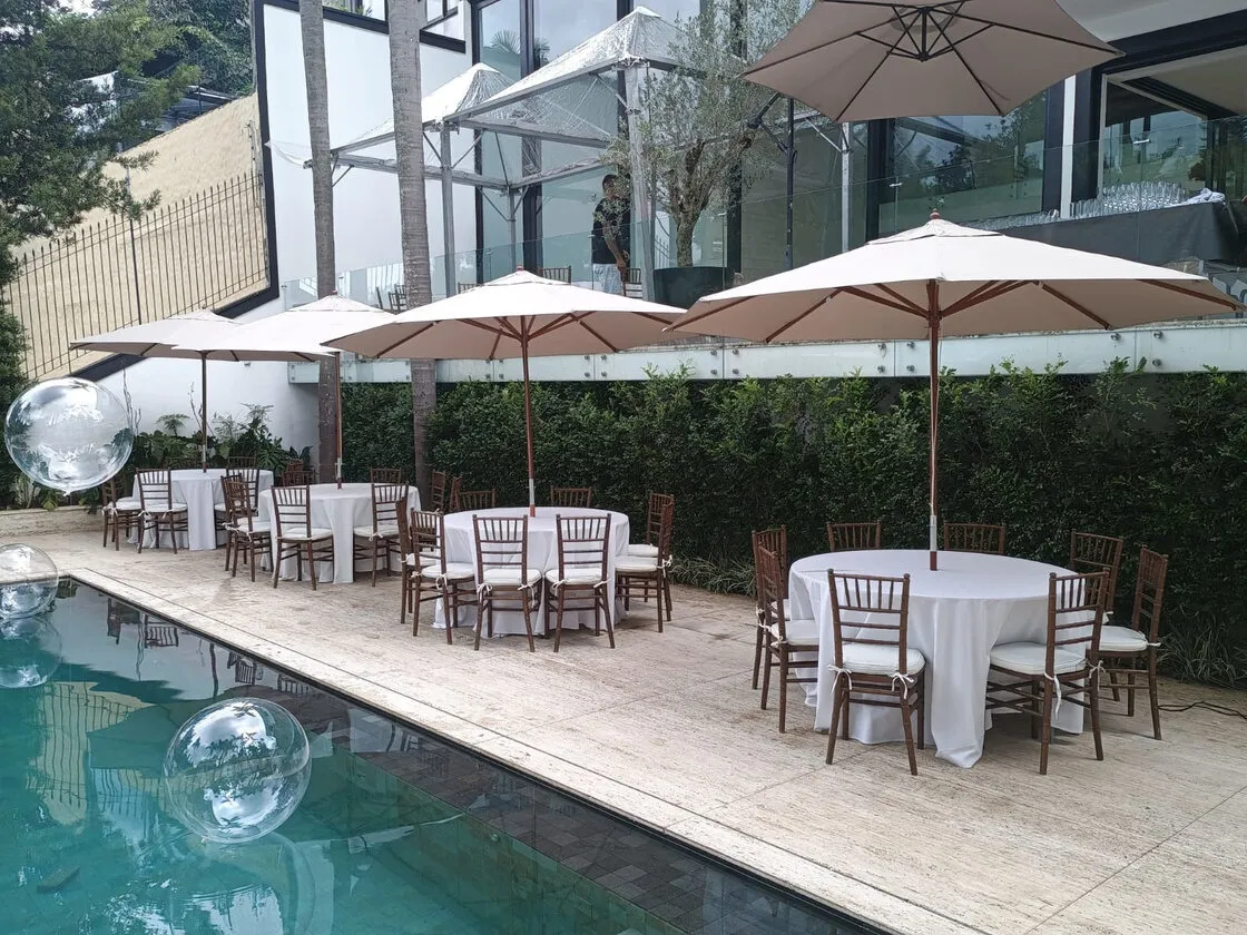 Ombrelones crus na beira da piscina com cadeiras Tiffany