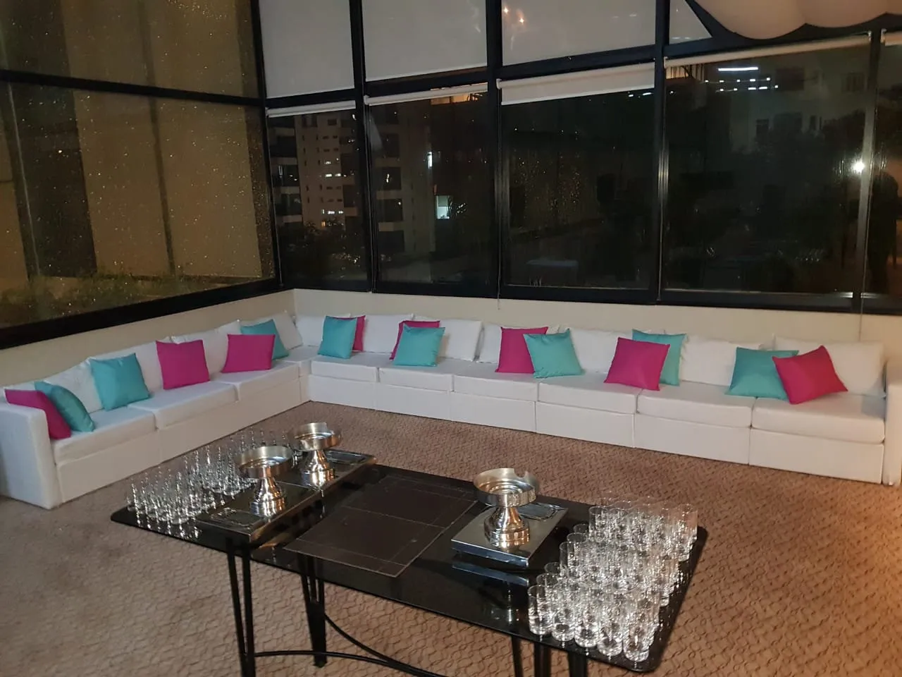 Sofá modular branco em L com almofadas pink e azul-turquesa