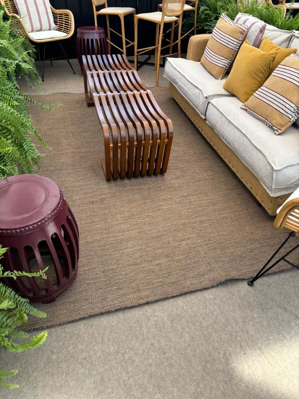 Tapete de sisal no lounge com almofadas listradas