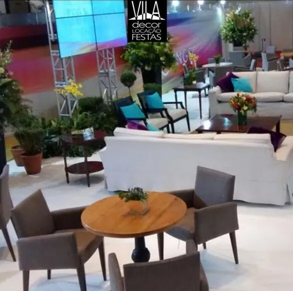 Lounge com sofás brancos, almofadas turquesa e bistrô de madeira
